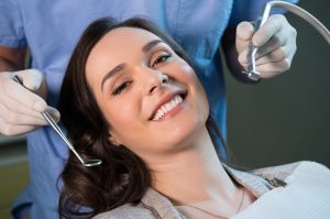 woman in dental chair smiling during a procedure