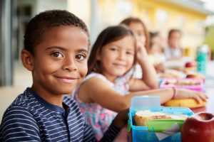 children with boxed lunches at school