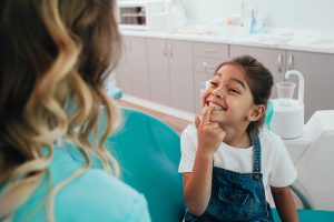 young patient shows off her teeth during a dental appointment