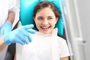 young patient smiles as dentist explains results of dental checkup