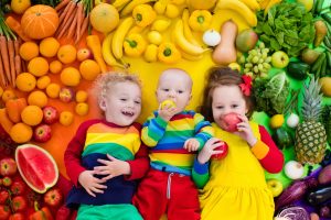 children surrounded by colorful fruits