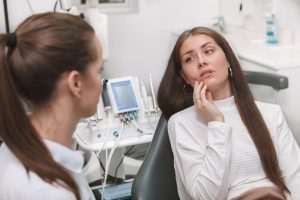 patient explains tooth pain to dentist